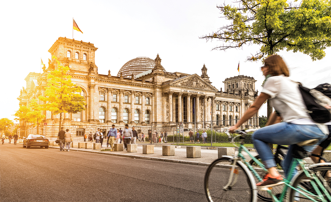 Cycling past the historic Reichstag building. Photography: Shutterstock / CanadaStock.