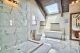 The master bathroom features Calacatta marble, his-and-hers sinks, glass shower, skylight, and a free-standing bathtub.
