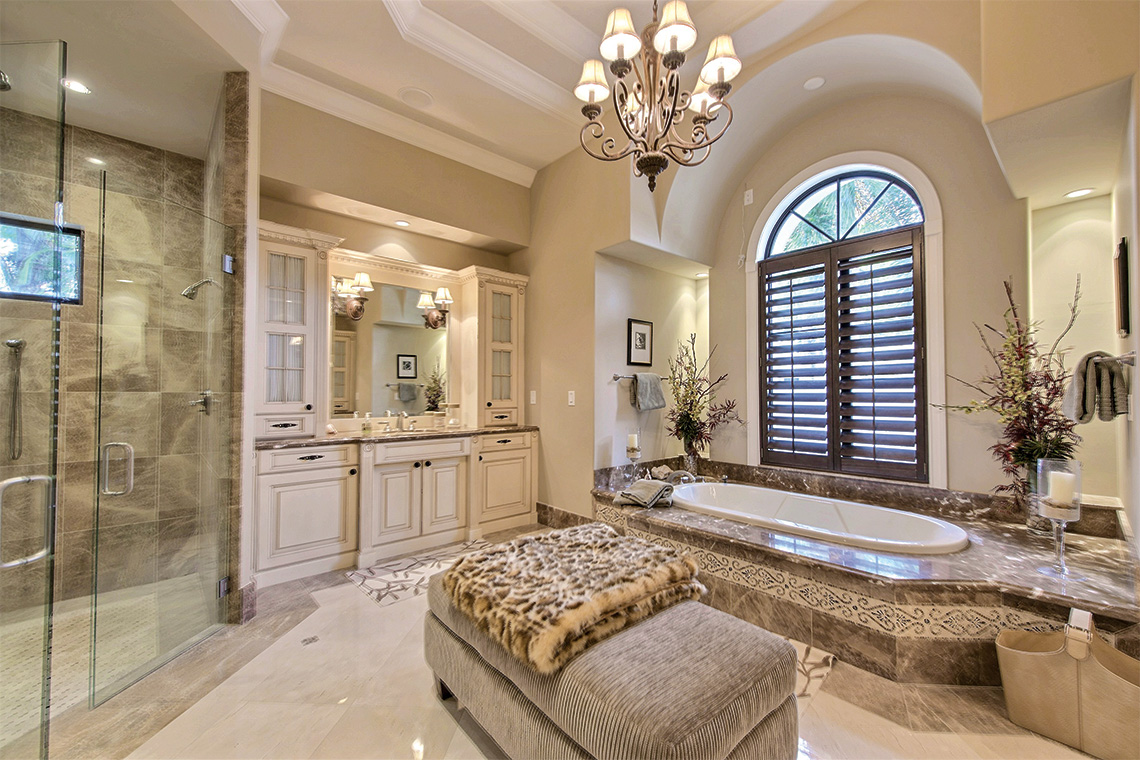 Master bath incorporates his-and-hers sinks, a private bidet and toilet room and a contemporary-styled chandelier. Photography: Coldwell Banker Residential Real Estate.