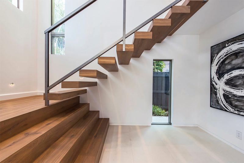 The staircase’s glass railings are steel-framed and low-iron. Photography: Tim Singer & Associates, Coldwell Banker Florida.