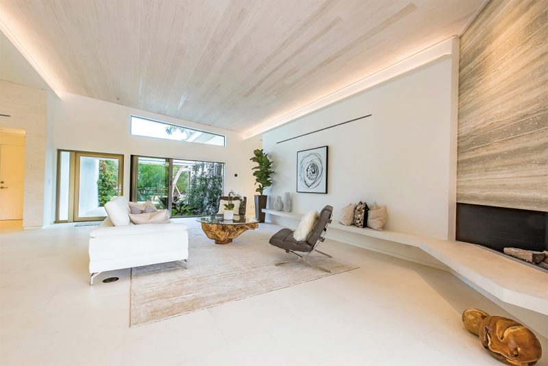 The floating concrete bench in the living room is finished in white micro-cement by Alternative Constructors.Photography: Tim Singer & Associates, Coldwell Banker Florida.