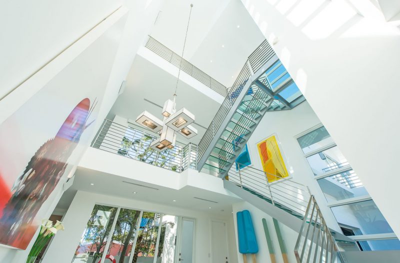 The glass staircase allows the artworks displayed on each floor to be seen from any floor. Photography by Eric Igualada, Spectrum Aerial Video & Photography