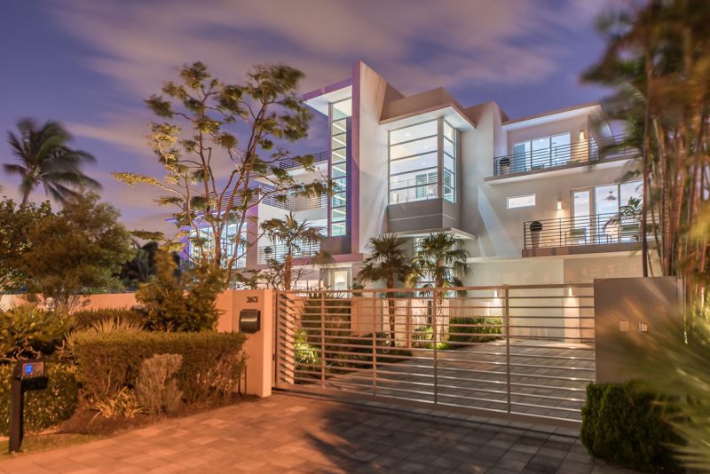 Black olive trees can be found throughout the exterior of the residence. Photography by Eric Igualada, Spectrum Aerial Video & Photography