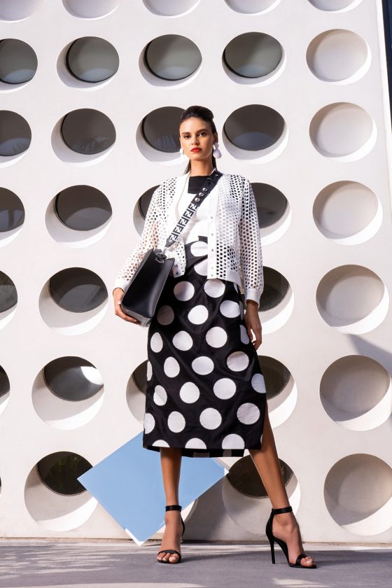 White Earrings by Zara, pricing available upon request at Zara. Runaway Tote by Fendi, pricing available upon request at Saks Fifth Avenue. Strap You Fabric Shoulder Strap by Fendi, $630, available at fendi.com. Ali Top by A.L.C, $195, available at alcltd.com. Knit Top by Helmut Lang, pricing available at helmutlang.com. Gathered Polka Dot Satin Jacquard Midi Skirt by Carolina Herrera, $745, available at net-a-porter.com. Long Sleeve Lace Jacket by Akris Punto, pricing available upon request at Saks Fifth Avenue.